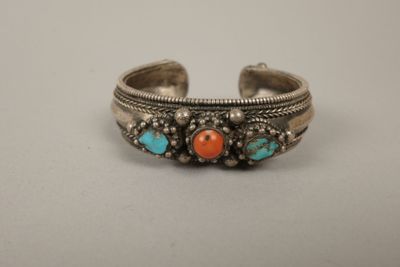 un bracelet manchette en argent orné de pierres turquoise et orange