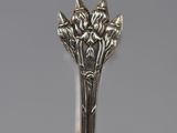 a close up of a spoon with flowers on it on a table