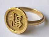 une bague en or sur laquelle est gravé un caractère chinois