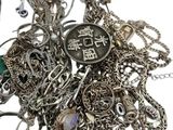 a pile of silver jewelry and a pair of scissors