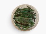 dried green beans in a bowl on a white surface