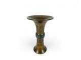 an old brass vase with a green handle on a white background