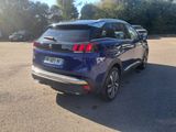 the rear end of a blue car parked in a parking lot