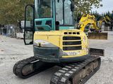 a yellow and green construction vehicle parked in a parking lot
