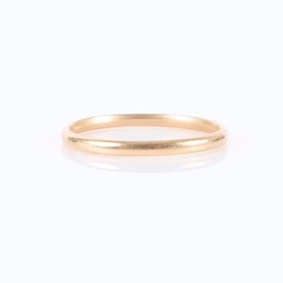 gros plan d'une bague en or sur fond blanc