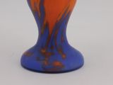 a blue and orange vase sitting on a white surface