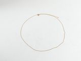 un collier en or orné d'une étoile, posé sur une surface blanche