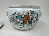 a white bowl with a painting on it next to a small plate