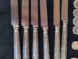 a lot of knives and spoons that are on the table