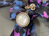 a tie with a coin on it that is tied to a ribbon