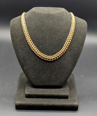 un collier à chaîne en or sur un présentoir pour mannequin