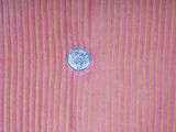 a coin sitting on top of a pink striped table cloth
