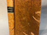 an old book sitting on top of a table with a piece of paper sticking out of it