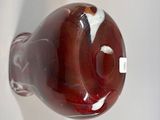 a glass vase with a red and white design on it