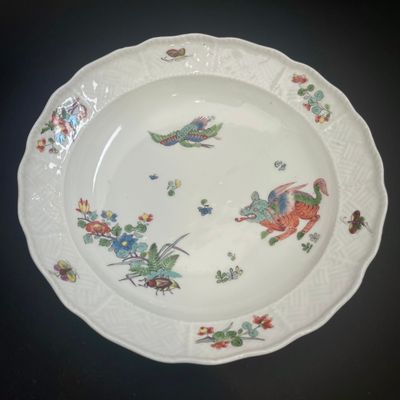 une assiette blanche ornée d'un motif représentant un oiseau et des fleurs
