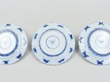 three blue and white plates with floral designs on them on a white surface