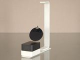 a black and white clock on a stand on a table