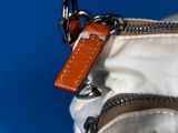 a small white bag with a brown tag on it