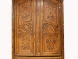 une photo d'une armoire en bois dont les portes sont ornées de sculptures