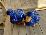 deux oiseaux en céramique bleue posés sur une table en bois