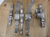 four watches on a wooden board on a table