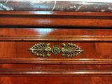 a close up of a wooden dresser with a marble top
