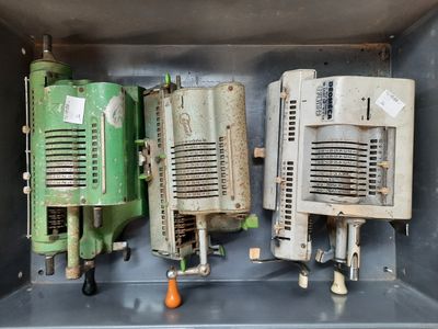 trois vieilles machines vertes et blanches dans une boîte en métal