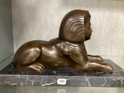 a bronze statue of a lion laying on a marble base