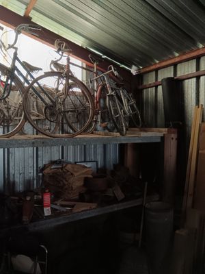 many bikes that are sitting on a shelf in a shed