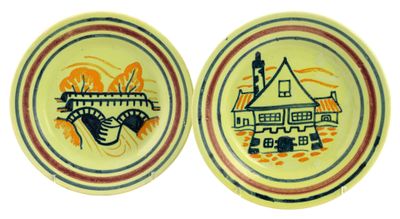 two yellow plates with blue and red designs on them on a white surface