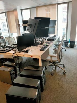 une salle où se trouvent de nombreux ordinateurs et bureaux