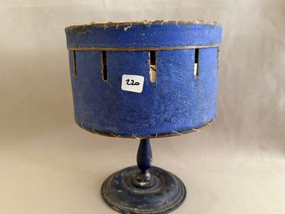 un petit vase bleu posé sur un socle, muni d'une étiquette