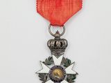 un gros plan d'une médaille ornée d'un ruban rouge sur fond blanc