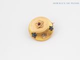 yellow gold plated brooch with black and white stars on it