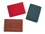 trois portefeuilles en cuir de couleurs différentes sur fond blanc
