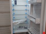 an open refrigerator with its door open in a garage