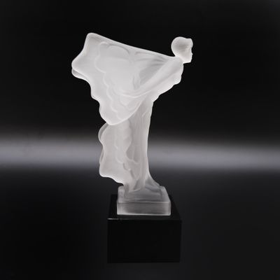 sculpture représentant une femme vêtue d'une robe blanche fluide, posée sur un socle noir