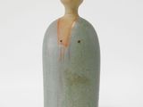 une petite figurine en céramique représentant une femme coiffée d'un chapeau
