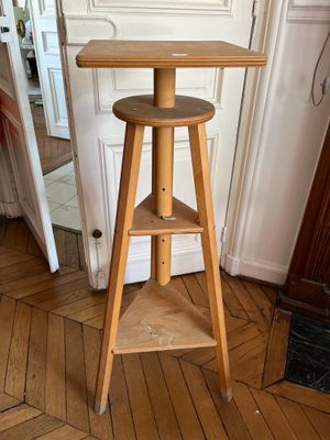 une table en bois sur laquelle est posé un tabouret, dans une pièce