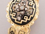 an image of a gold and black broochle with diamonds