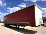 a red semi trailer parked in a parking lot