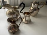 three silver teapots sitting on a table next to each other