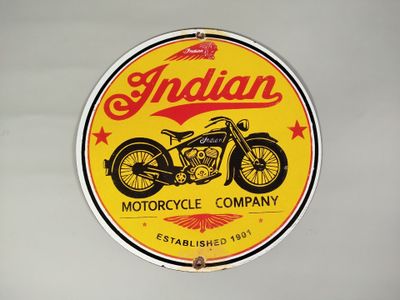 une enseigne jaune et rouge de la marque de motos « Indian » sur un mur blanc