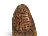 une image représentant une bague en bois sculpté sur laquelle figurent des caractères chinois