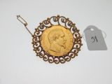 a close up of a gold coin with a chain attached to it