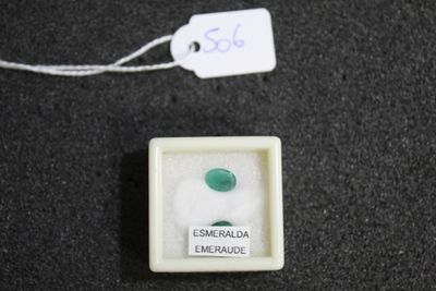 a small white box with a green stone inside of it