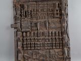 une image représentant une plaque en bois sculptée posée sur un fond blanc