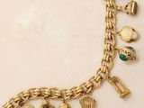 an image of a gold bracelet with charms on a white surface