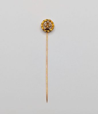 un gros plan d'une broche en or et diamants fixée sur une tige