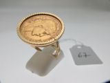 une bague en or ornée d'une pièce de monnaie et d'une étiquette de prix